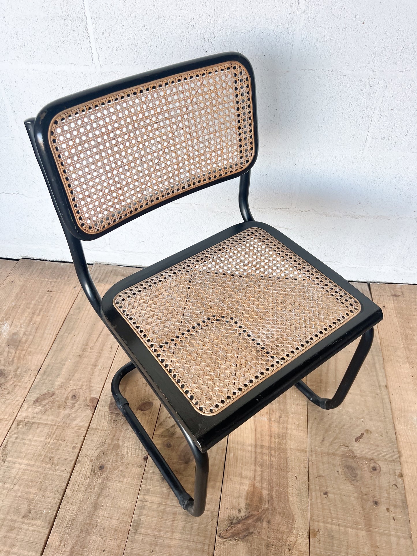 Chaise cannée en bois, cannage et métal, le métal à quelques marques, le bois est abimé sur la droite.