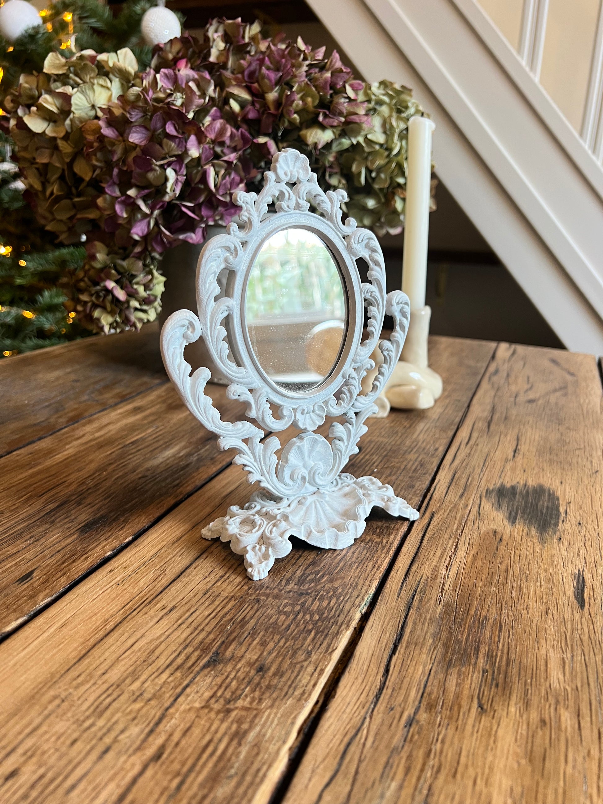 Mini miroir baroque, orientable, en métal, peint en beige.