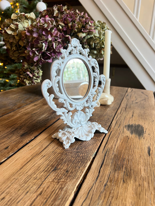 Mini miroir baroque, orientable, en métal, peint en beige.
