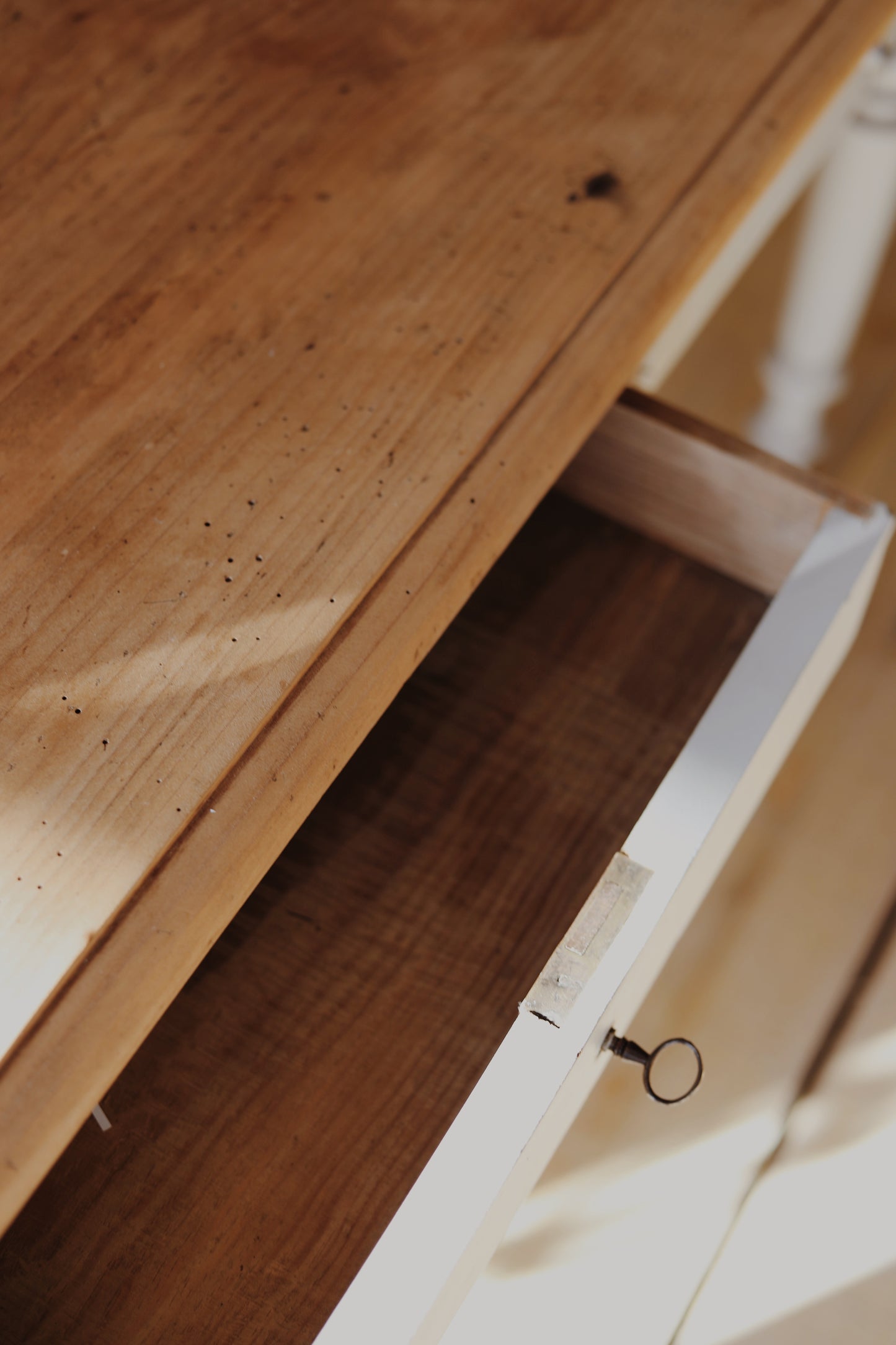 Joli bureau en bois avec un plateau en pin brut et deux tiroirs, le piétement est peint en beige, la serrure ne fonctionne pas. La peinture est abimée à certains endroits.