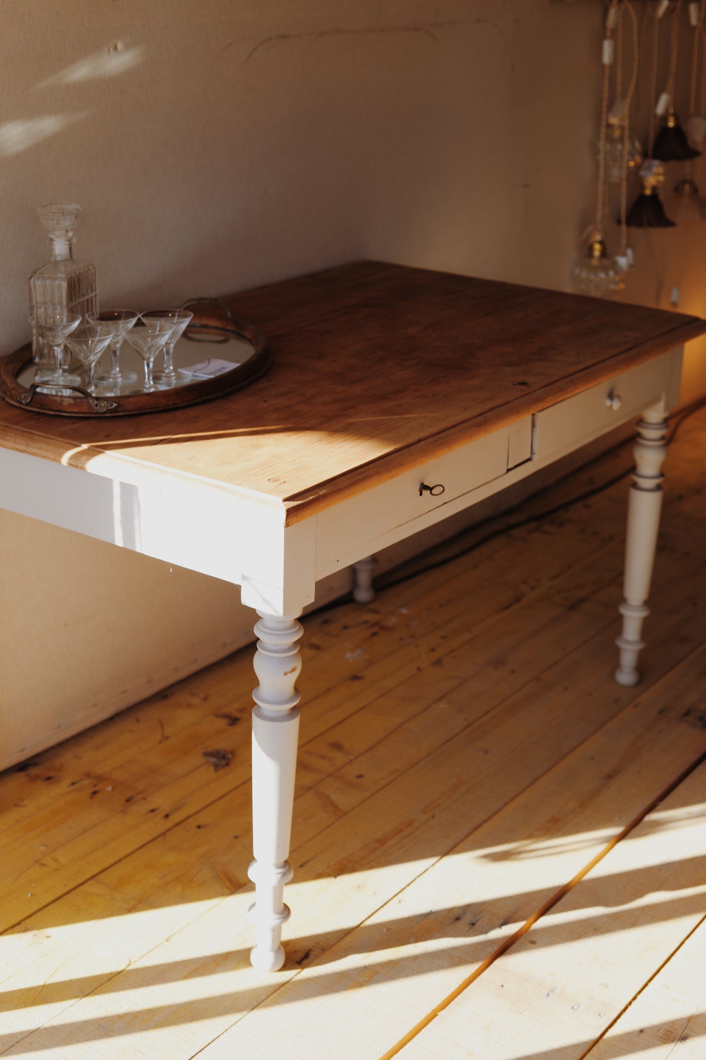 Joli bureau en bois avec un plateau en pin brut et deux tiroirs, le piétement est peint en beige, la serrure ne fonctionne pas. La peinture est abimée à certains endroits.