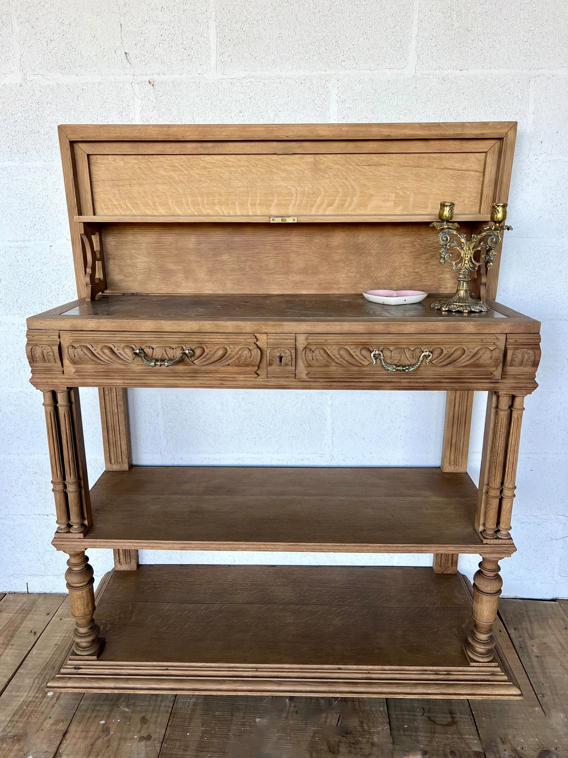 Console en chêne, le plateau se soulève pour laisser place à une tablette en marbre (fendue d'un coté) et à une petite étagère. Idéal en vanity dans une salle de bain, en console dans une entrée ou dans un salon, le compartiment au milieu sert à fermer les tiroirs mais la clé n'est pas présente.