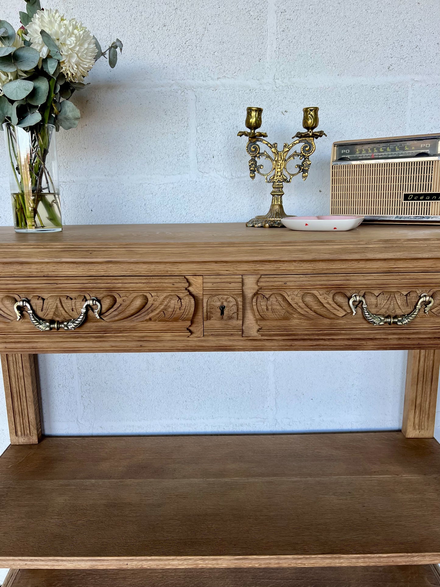 Console en chêne, le plateau se soulève pour laisser place à une tablette en marbre (fendue d'un coté) et à une petite étagère. Idéal en vanity dans une salle de bain, en console dans une entrée ou dans un salon, le compartiment au milieu sert à fermer les tiroirs mais la clé n'est pas présente.