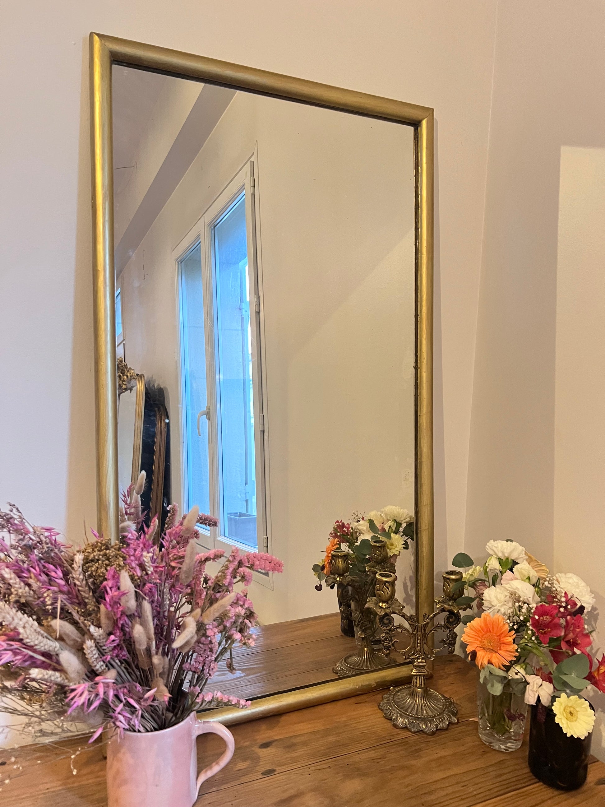 Miroir rectangulaire doré, le cadre est un peu abîmé à certains endroits, la vitre aussi.