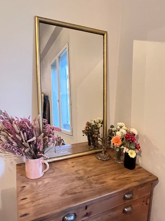Miroir rectangulaire doré, le cadre est un peu abîmé à certains endroits, la vitre aussi.