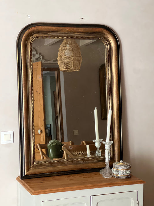 Miroir louis philippe noir et doré, cadre un peu abimé en haut, vitre légèrement piquée.