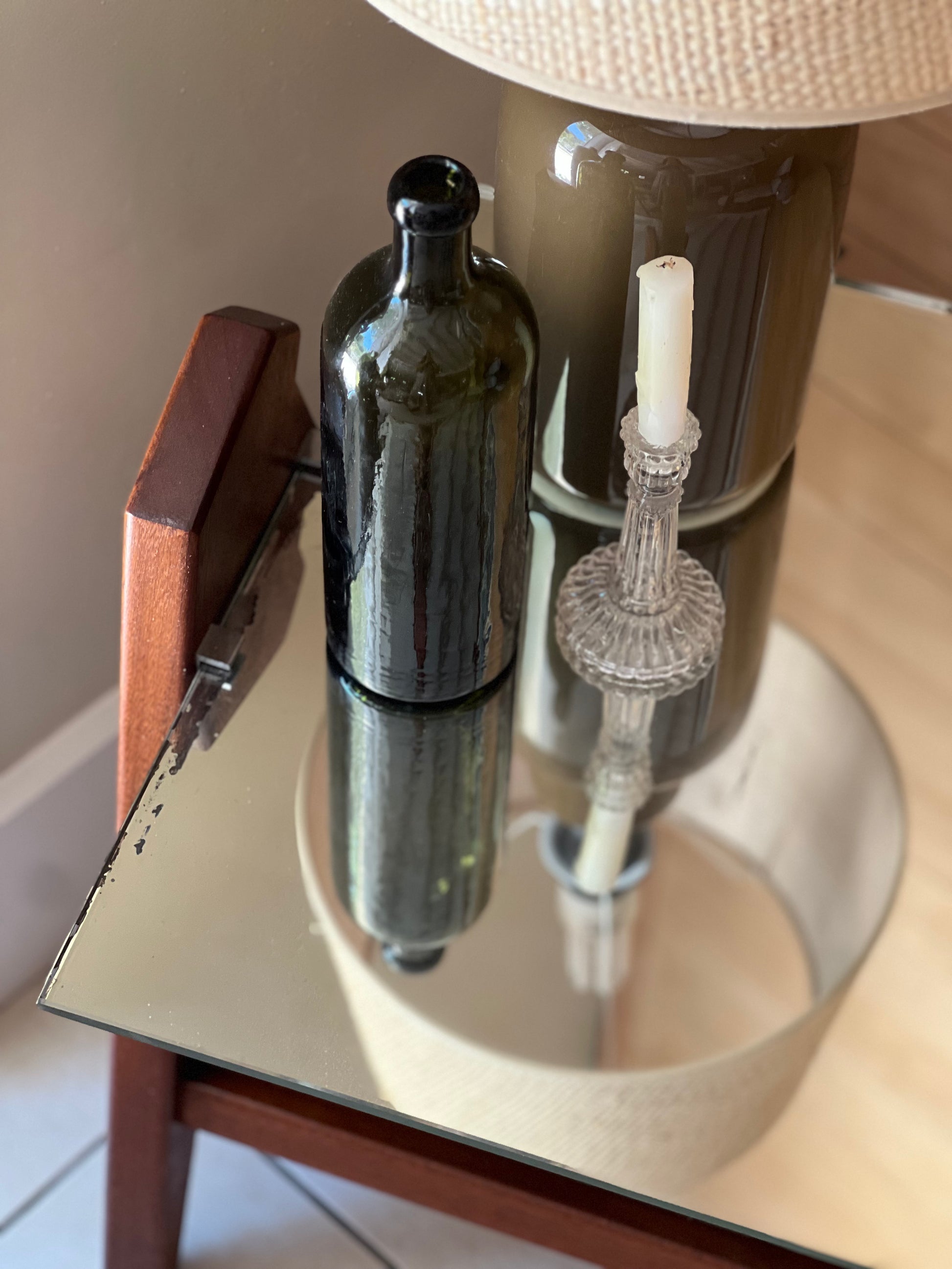 Table basse années 60, plateau en miroir, piqué sur les bords, piétement en bois.