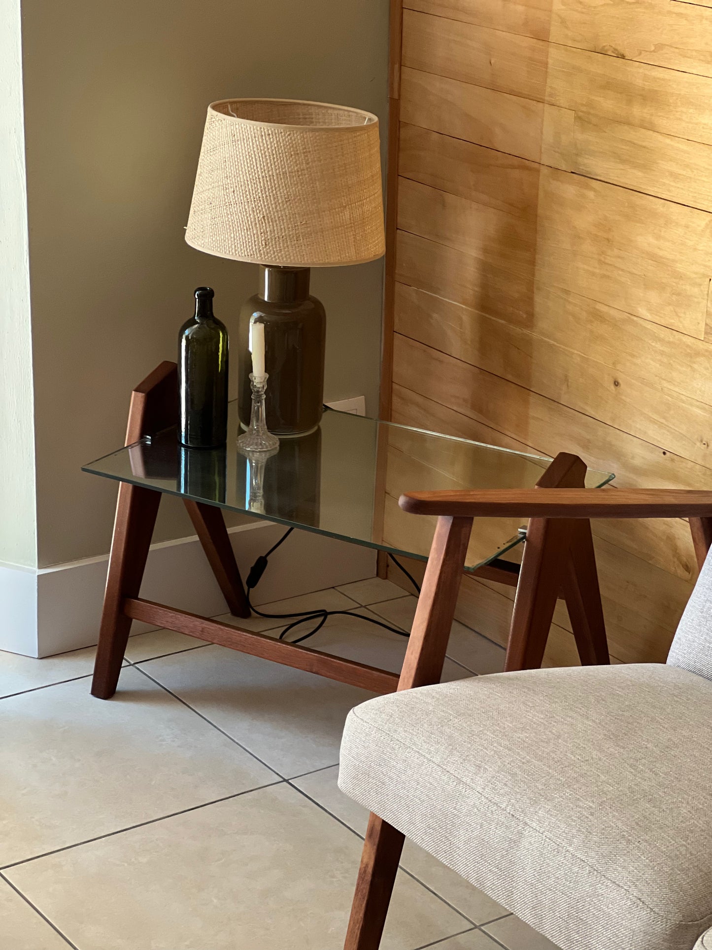 Table basse années 60, plateau en miroir, piqué sur les bords, piétement en bois.
