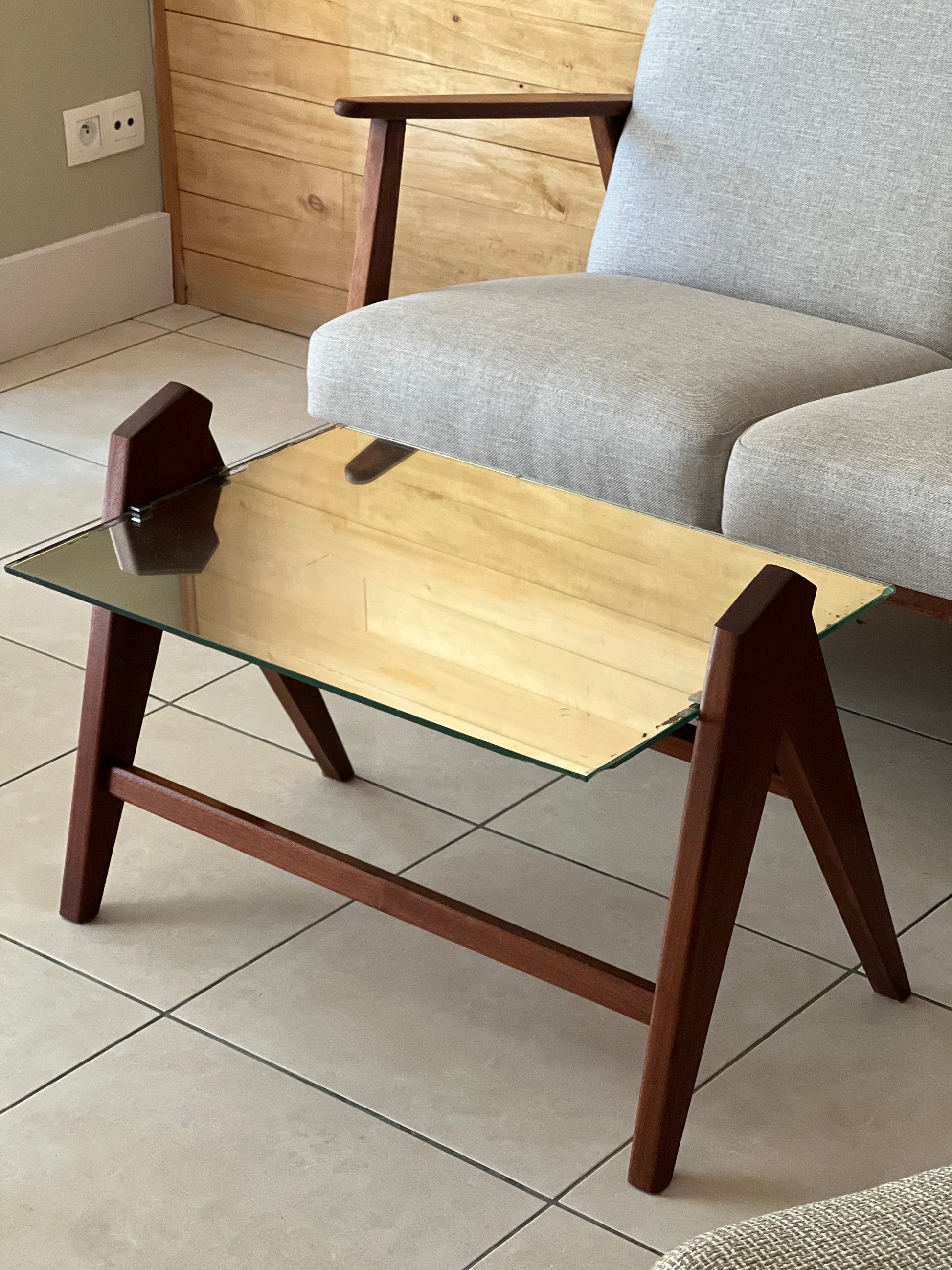 Table basse années 60, plateau en miroir, piqué sur les bords, piétement en bois.