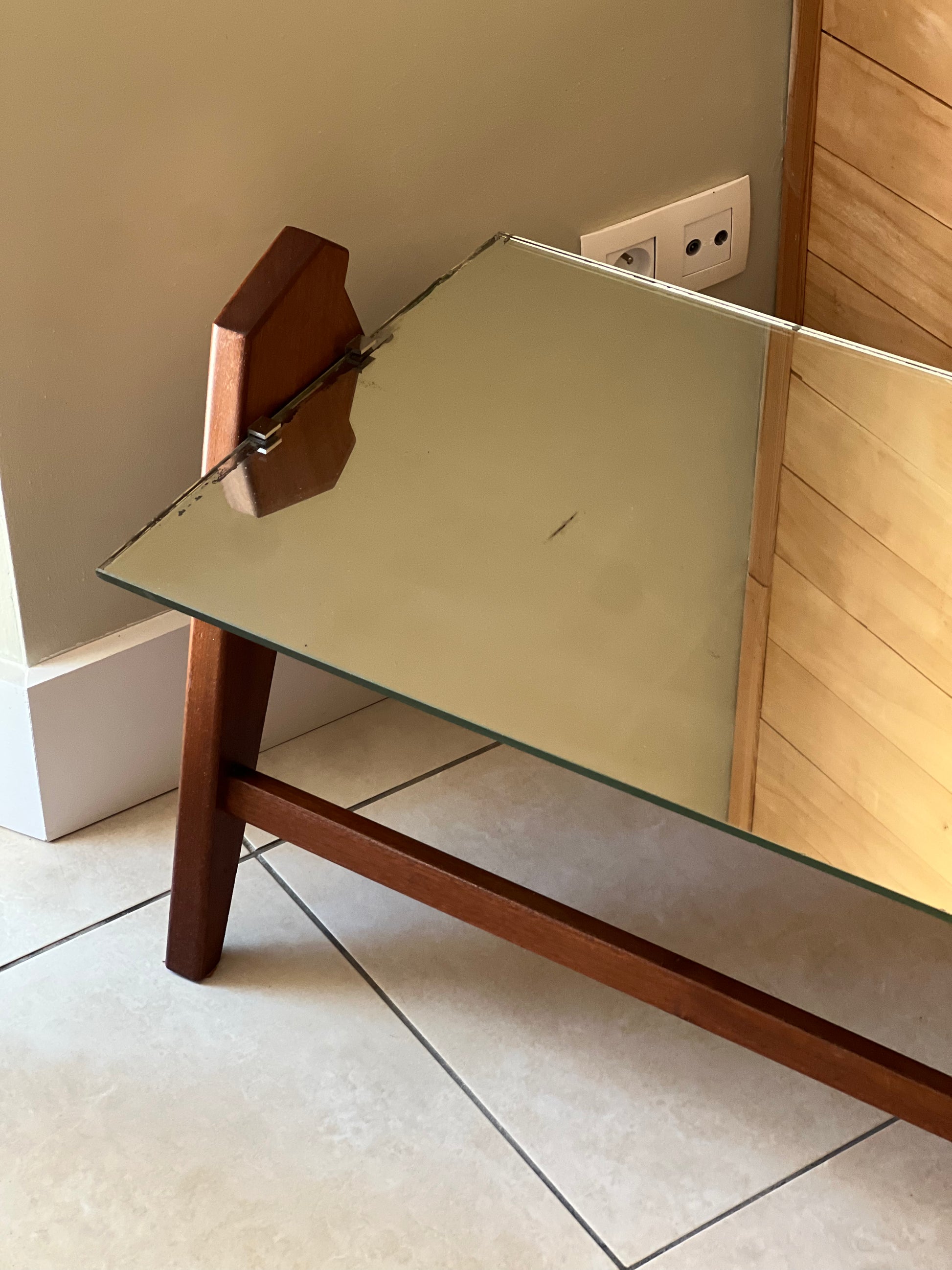 Table basse années 60, plateau en miroir, piqué sur les bords, piétement en bois.